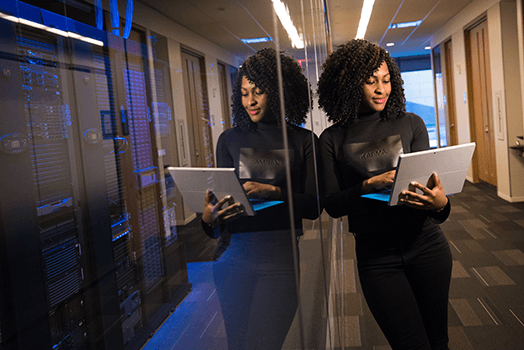 Expert level: Woman working with laptop in a data center